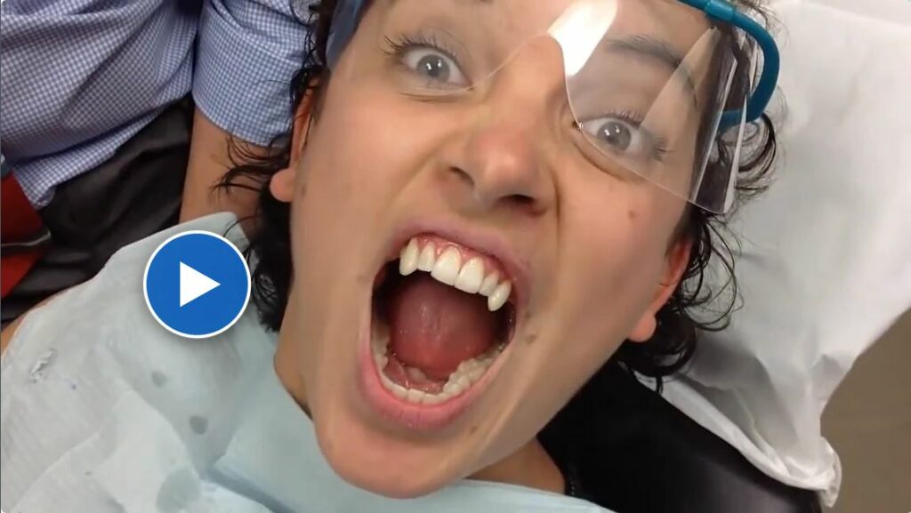 Patient in the dental chair showing off vampire fangs at Dentist at Lelem Village